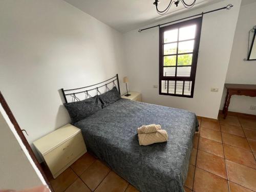 ein Schlafzimmer mit einem Bett mit einer Tasche darauf in der Unterkunft Olivia’s house in Maspalomas