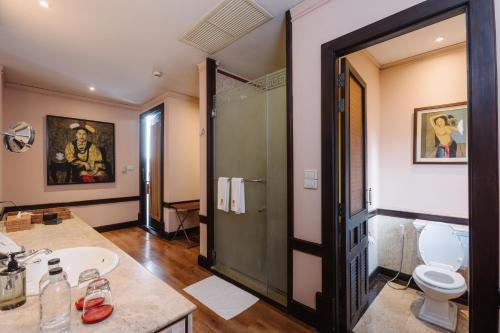 a bathroom with a shower and a toilet and a sink at Lunar Mansion Hotel in Chiang Mai