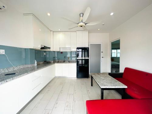 a living room with a red couch and a kitchen at Apartment - 1 Bed Condo in Saigon center District 1 - 1 Phòng ngủ Riêng, Phạm Viết Chánh, Quận 1 in Ho Chi Minh City