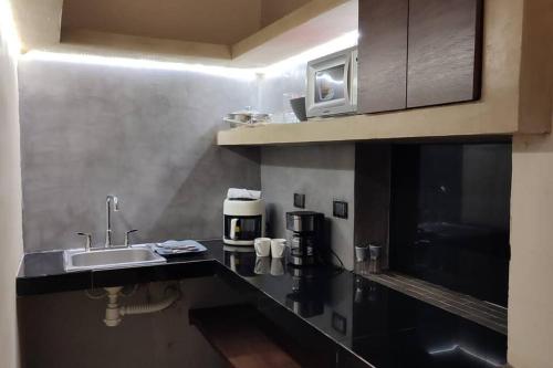 a kitchen with a sink and a coffee maker at Ko'ox 52 in Mérida