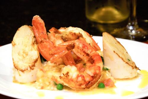 a white plate with shrimp and vegetables on a table at Bristol International Guarulhos in Guarulhos