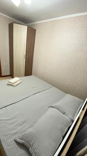 a bed with two pillows on it in a room at 2х комнатная квартира на Толе би in Taraz