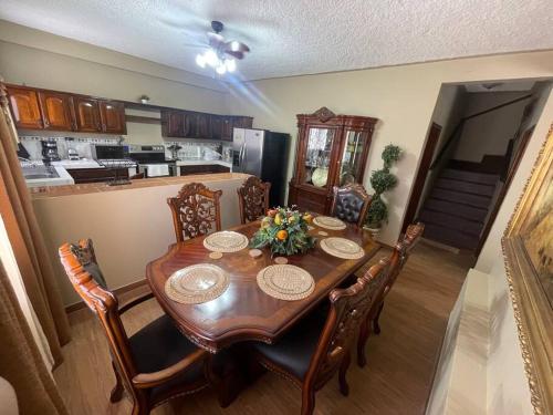 una sala da pranzo con tavolo e sedie e una cucina di Casa del Ángel #10 a La Ceiba