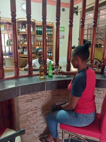 two girls sitting at a bar in a restaurant at THE DESERT ROSE HOTEL VOI in Voi