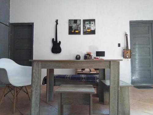- une table en bois dans une chambre avec une guitare sur le mur dans l'établissement Hostel La Escondida 094625953, à Parque del Plata