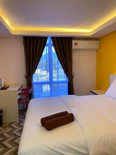 une chambre d'hôtel avec un lit et une serviette. dans l'établissement D SEGA HOTEL, à Macang