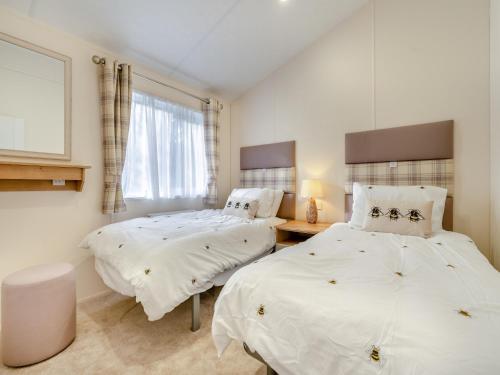 a bedroom with two beds and a window at Wainstones Rocks - Uk42938 in Great Broughton
