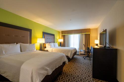 a hotel room with two beds and a television at Holiday Inn Murfreesboro by IHG in Murfreesboro