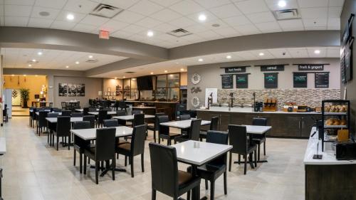 a restaurant with tables and chairs and a bar at Holiday Inn Murfreesboro by IHG in Murfreesboro