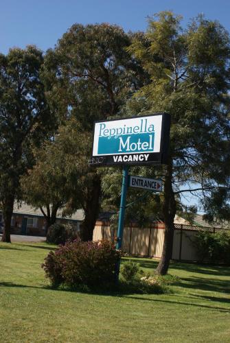 a sign for a motel with trees in the background at Peppinella Motel in Ballarat