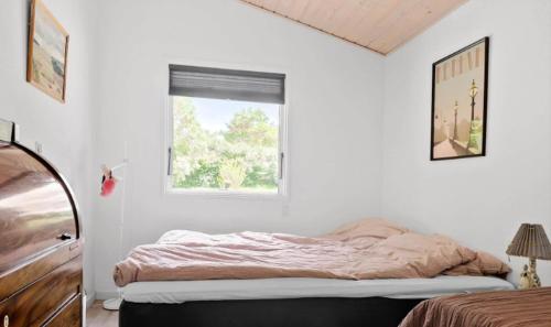 Dormitorio blanco con cama y ventana en Cozy Cottage In Scenic Surroundings, en Melby