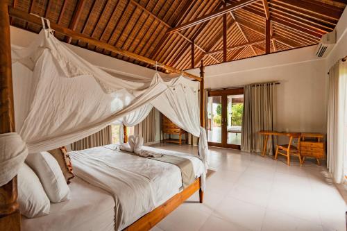 Schlafzimmer mit einem Bett mit Moskitonetz in der Unterkunft Casa Margarita Bali in Canggu