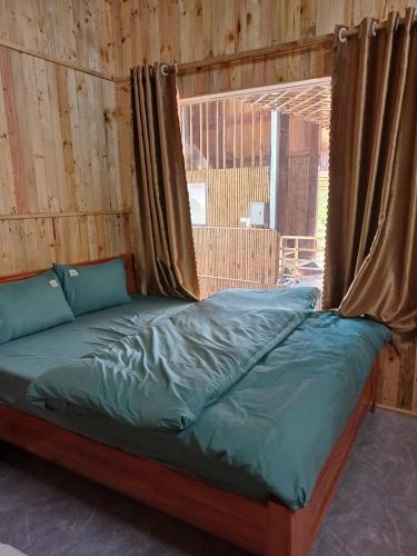 a bed in a wooden room with a window at Hill House in Mai Chau