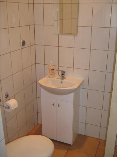 a white bathroom with a sink and a toilet at Villa Centrum, BEZPŁATNY PARKING in Malbork