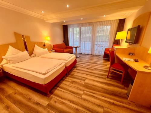 HeimbuchenthalにあるLandhotel Heimathenhofのベッドとデスクが備わるホテルルームです。