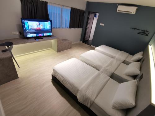 Schlafzimmer mit einem Bett und einem Flachbild-TV in der Unterkunft HOTEL SENTOSA KOTA BHARU Kelantan in Kota Bharu