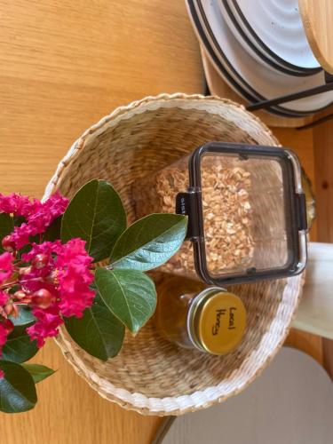a bottle of oil next to a basket with a flower at Tweed Hinterland Eco Cabin in Byangum