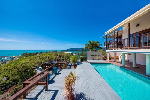 a house with a swimming pool next to the ocean at Airlie Beach Seaviews in Airlie Beach