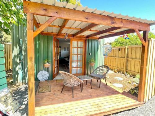 una terraza de madera con sillas y pérgola en Heart of Witchcliffe en Margaret River