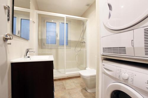 a bathroom with a toilet and a sink and a washing machine at Apartment Park&Beach Deluxe in Barcelona