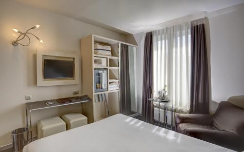a hotel room with a bed and a couch at Hotel Vivaldi in Puteaux
