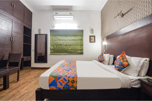 1 dormitorio con 1 cama grande y escritorio en FabHotel City Chalet Saket, en Nueva Delhi
