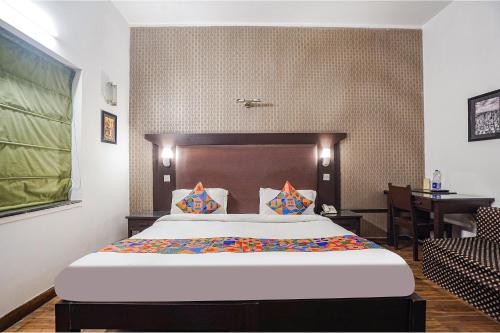 a bedroom with a bed and a desk in a room at FabHotel City Chalet Saket in New Delhi