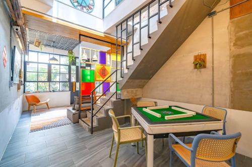 a room with a ping pong table and stairs at 樹沐包棟民宿 Shine tree house in Tainan