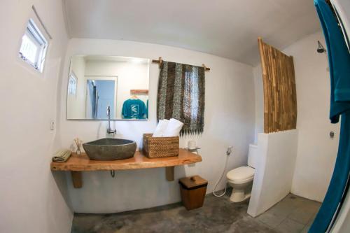 La salle de bains est pourvue d'un lavabo et de toilettes. dans l'établissement Katiet Beach Resort Mentawai Lances Right HTS, à Katiet