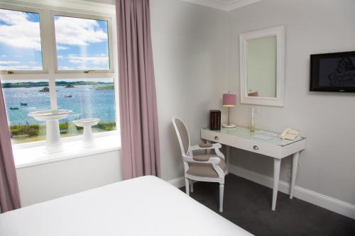 St Martins的住宿－聖馬丁卡爾瑪酒店，一间卧室配有书桌、床和窗户。