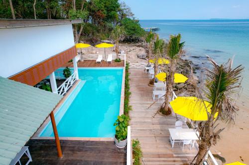 una casa con piscina, sillas y sombrillas en One Beach Private Villa, en Phumĭ Kaôh Rŭng Sâmlœ̆m Khnŏng