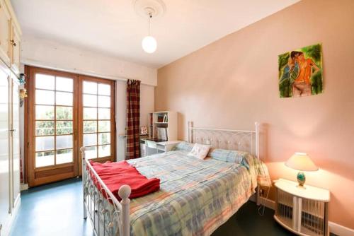 Un dormitorio con una cama con una manta roja. en appartement bordeaux, en Burdeos