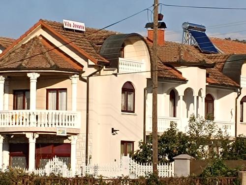 een wit huis met een wit hek ervoor bij Vila Jovana B in Rogljevo