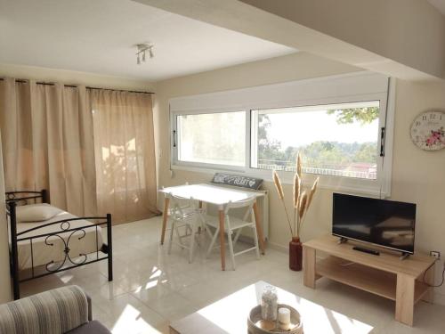 a living room with a table and a television at Horizon Seaview Apartment in Lassi