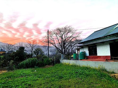 dom z czerwoną werandą i niebem z chmurami w obiekcie Sabitri Homestay w mieście Panaoti
