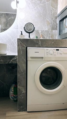 a white washing machine in a kitchen next to a counter at Arbona Apartment Ι in Vóroi
