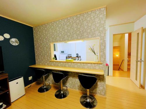 a bathroom with a counter with a mirror and stools at 無料駐車場 3階建て一軒家 家族グループ最適 3寝室ヴィラ Usj 道頓堀 難波近い 子連れ歓迎 in Osaka