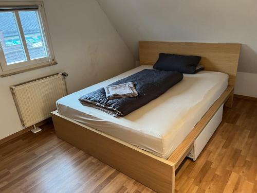 Cama en habitación pequeña con suelo de madera en Wunderschöne Maisonette Wohnung in Wendelstein - Messenähe - Nürnberg, en Wendelstein