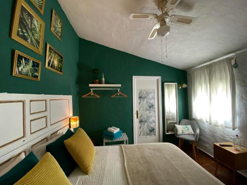 um quarto com uma cama e uma parede verde em Casa Campana em Arcos de la Frontera