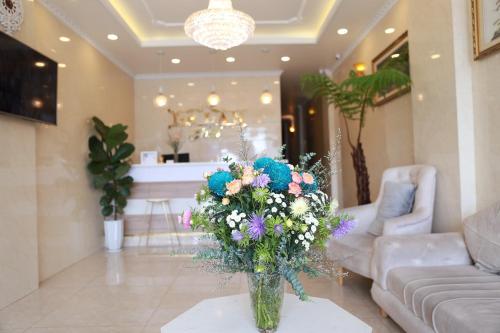 um vaso de flores numa mesa numa sala de estar em DẠ LAN HOTEL em Da Lat
