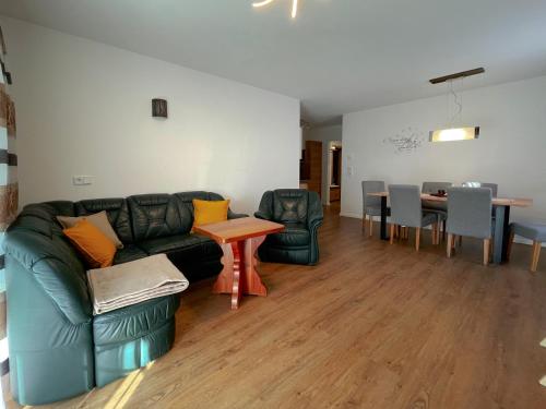 a living room with a couch and a table at Wohnen am Almufer - Ferienwohnung Straßmair in Grünau im Almtal