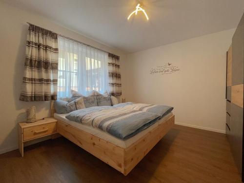 a bedroom with a bed and a window at Wohnen am Almufer - Ferienwohnung Straßmair in Grünau im Almtal