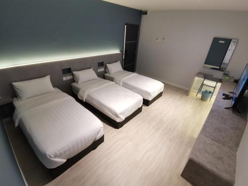 Habitación de hotel con 2 camas y TV de pantalla plana. en HOTEL SENTOSA KOTA BHARU Kelantan, en Kota Bharu