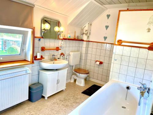 y baño con bañera, aseo y lavamanos. en Ferienhaus Delia, en Dannewerk