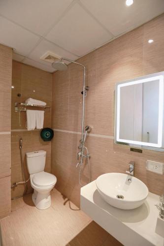 a bathroom with a sink and a toilet and a mirror at Keypad Hotel - 28 Dịch Vọng Hậu in Hanoi