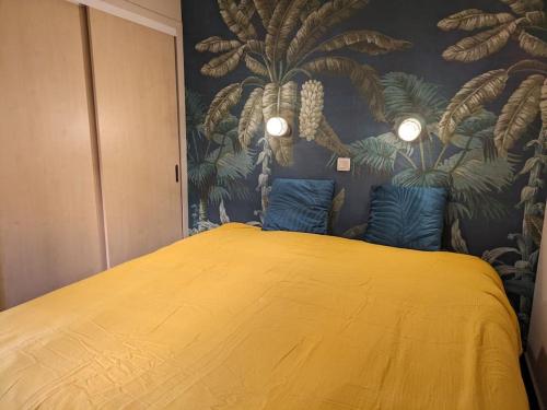 - une chambre avec un grand lit jaune et du papier peint dans l'établissement Superbe appartement Cannes avec Piscine 1 chambre, à Cannes