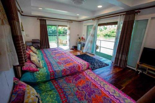 1 dormitorio con cama y ventana grande en บ้านกลางโดม Baan Klang Dome, 