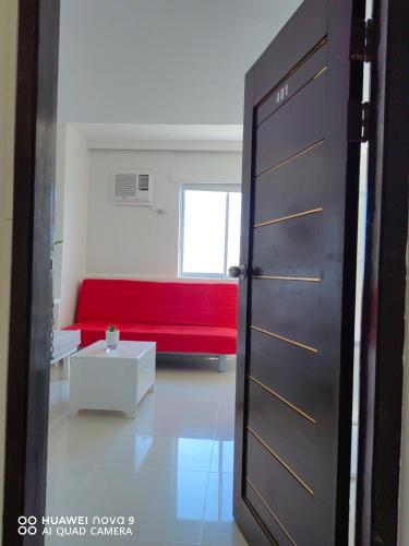 a red couch in a living room with a red bench at Mecasa Hotel in Boracay