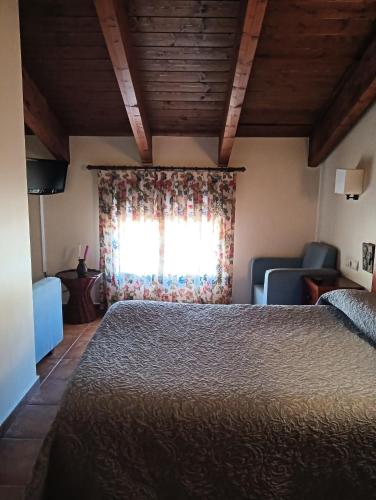 a bedroom with a bed and a window at Hostal Sol de la Vega in Albarracín