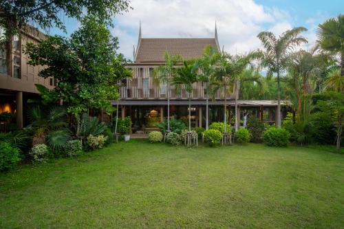 an exterior view of a house with a yard at Syama Residence and Café in Phra Nakhon Si Ayutthaya
